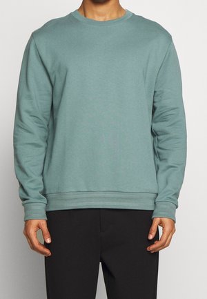 Hellblauer Crewneck-Sweatshirt mit langen Ärmeln, gerippten Bündchen und Saum. Hergestellt aus weichem Material, mit lässiger Passform und minimalistischem Design.