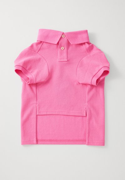 Tricou polo scurt cu mâneci scurte, de culoare roz aprins, cu două nasturi și guler, așezat pe o suprafață deschisă la culoare.