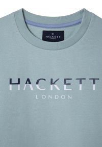 T-shirt in cotone verde chiaro con scollatura tonda. Presenta un logo stampato audace e a contrasto "HACKETT LONDON" in bianco e nero.