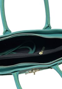 Tyrkysová kabelka vyrobená z texturované kůže. Obsahuje dvě ucha, zipovou vnitřní kapsu a zlatý uzávěr. Černý vnitřek.