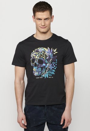 T-shirt nera con un design di teschio colorato e accenti floreali. Realizzata in un tessuto morbido, ha una vestibilità classica e maniche corte.