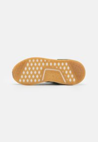 Shoe sole shown from below with honeycomb pattern, gum rubber material, and curved white detailing in the middle section.