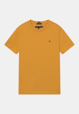 Gelbes Baumwoll-T-Shirt mit Rundhalsausschnitt, kurzen Ärmeln und einem kleinen Emblem auf der Brust. Glatte Textur und minimalistisches Design.