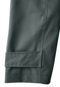 Dark green fabric of tapered pants featuring a clean hem and flat-fell seam with a squared fold at the cuff. Smooth texture, minimal detailing.