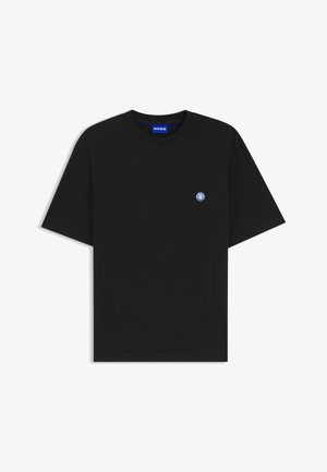 T-shirt noir à manches courtes col rond avec petit logo circulaire bleu et blanc sur la poitrine gauche et étiquette de marque bleue à l'intérieur du col.