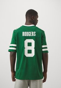 Žalias sportinis džersis su baltais akcentais, ant nugaros esantis vardas "RODGERS" ir numeris "8". Trumpi rankoviai ir klasikinis kirpimas.