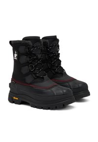 Sorte vinterstøvler med gummisåler, struktureret stofoverdel, justerbare snørebånd, røde syninger og et logo-patch på siden. Vibram-branding er synlig.