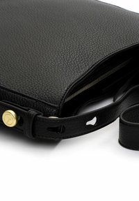 Musta nahkainen olkalaukku, jossa on teksturoitu pinta, vetoketjullinen suljenta, säädettävä hihna ja kultaisen sävyn metalliosat.