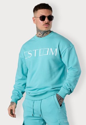 Turquoise sweatshirt with white "ESTEEM" logo. Features a crew neck, ribbed cuffs, and a relaxed fit, paired with matching pants.