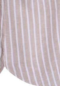 Tessuto di lino beige con strisce bianche verticali; consistenza morbida; presenta un orlo curvo e una leggera lucentezza. Attenzione totale al design del tessuto.