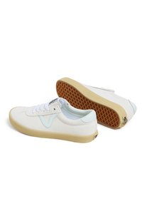 White canvas sneakers with light blue accents, round toe, lace-up front, and curved sole. Textured rubber outsole with diamond pattern.