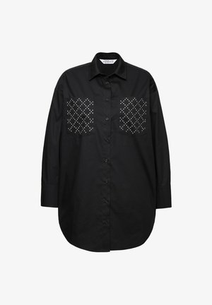 Mustapaita pitkilla hihoilla, jossa on kaksi taskua, joiden reunat on koristeltu hopeisilla niiteillä timanttikuviolla. Paita on sileä ja rento malli.