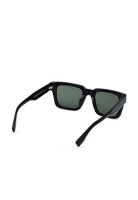 Lunettes de soleil rectangulaires noires avec des verres vert foncé, légèrement inclinées pour montrer à la fois les verres et les branches sur fond blanc.