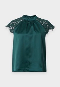 Blouse sans manches en satin vert foncé avec manches courtes en dentelle et col montant, dotée d'une petite fermeture bouton au dos.