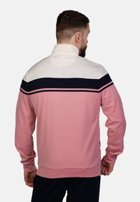 Rosa und weiße Sportpullunder mit hohem Kragen, ausgestattet mit marineblauen Streifen und einer strukturierten Oberfläche. Lange Ärmel und figurbetonte Passform.