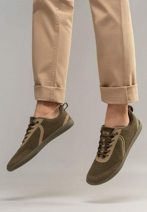 Czekoladowe siatkowe sneakersy z kontrastującymi beżowymi akcentami, zaokrąglony czubek i teksturowana gumowa podeszwa. W zestawie sznurówki i detal w postaci pętli na pięcie.