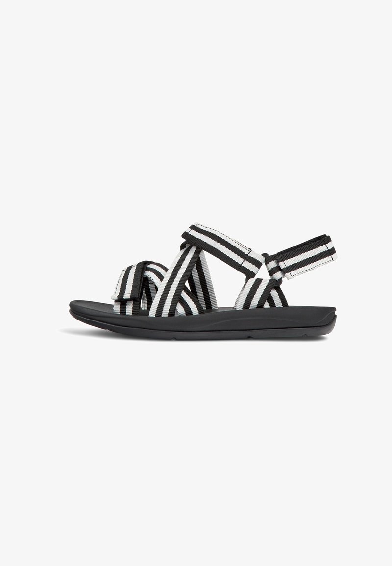 Black and white striped sandals with fabric upper straps and a cushioned black sole. Open-toe design with adjustable hook-and-loop fasteners.