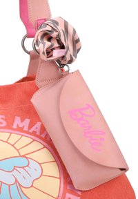 Tasche aus orangefarbenem Canvas mit pinkem Ledergriff und einem pinken Kartenetui. Sie zeigt ein farbenfrohes Grafikdesign einer Hand und einem gestreiften Haargummi.