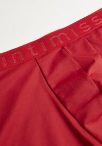Röda underkläder med en mjuk textur, med en matchande elastisk midjelet som är präglad med "intimissimi" i en diskret font.