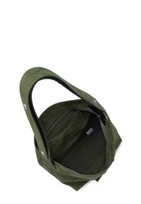 Sac fourre-tout en daim vert avec une grande ouverture, texture lisse, poches zippées doubles et détails de couture contrastés.