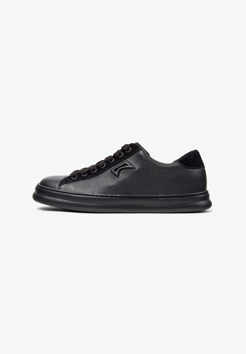 Sneaker in pelle nera con texture liscia, punta arrotondata, lacci neri, colletto imbottito e un logo discreto sul lato.