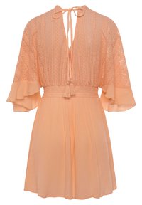 Perzikkleurige jurk met een gestructureerde stof, voorzien van een diepe V-hals, uitlopende mouwen en een koord taille met kwastjes.
