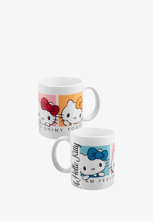 Tazza in ceramica bianca con due design di Hello Kitty su sfondi colorati. Da un lato si vedono il rosso e l'arancione, mentre dall'altro blu e rosa.