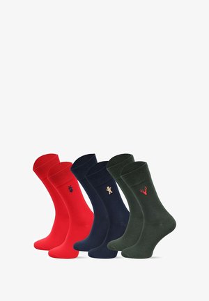 Cztery pary skarpet: czerwone z logo, granatowe z motywem piernika, ciemnozielone z jeleniem. Gładka tekstura, długość do połowy łydki, różne kolory.