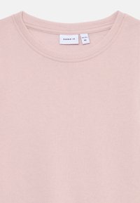 Felpa rosa chiaro con collo a girocollo a coste e texture morbida, etichettata con il marchio "name it" e tag della taglia per 1½-2 anni.