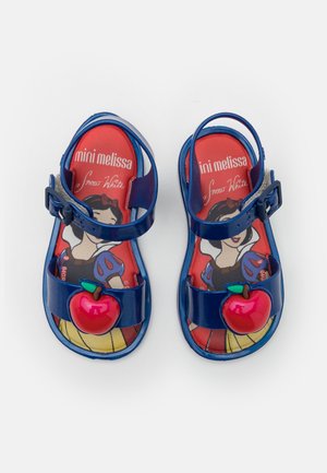 Børns blå sandaler med røde æbledekorationer og illustration af Snehvide på røde indlæg mærket "mini melissa Snehvide."