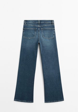Jean en denim bleu foncé avec une coupe large, comportant deux poches arrière et une taille standard. Texture lisse avec une finition classique.