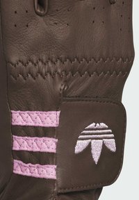 Brown leather glove featuring pink stitching, a textured surface, and a pink embroidered logo with horizontal stripes on the wrist area.