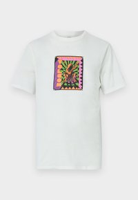 White cotton t-shirt featuring a square, colorful graphic with a frog design and text, set against a geometric background and accented edges.