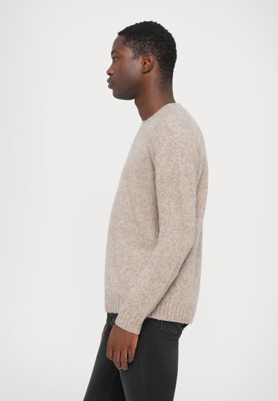 Maglione beige a maglia con scollatura rotonda e maniche lunghe, caratterizzato da una finitura morbida e testurizzata. Vestibilità slim con polsini e orlo a coste.