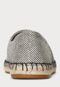 Espadriller med överdel i rutigt svart och vitt tyg, sula av jute rep och kontrasterande sömmar längs kanterna. Rund tådesign.