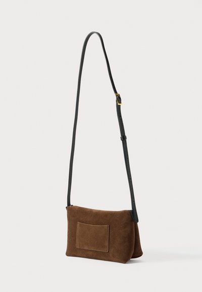Smeđa torbica od brušene kože s crnim podesivim remenom za nošenje preko tijela. Ima ravni prednji džep i mekan, teksturiran završetak.