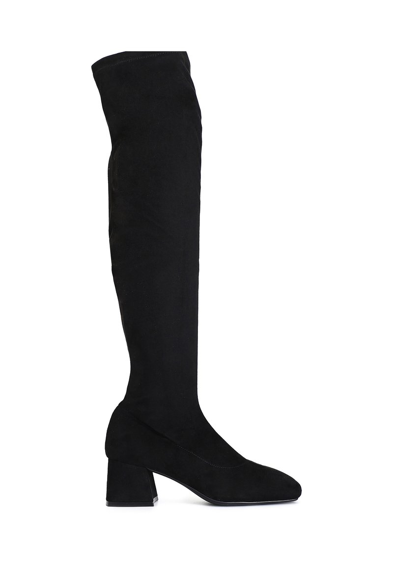 Botas negras hasta la rodilla, fabricadas con material suave y texturizado. Cuentan con un tacón grueso y una punta afilada. Diseño liso con un detalle mínimo.