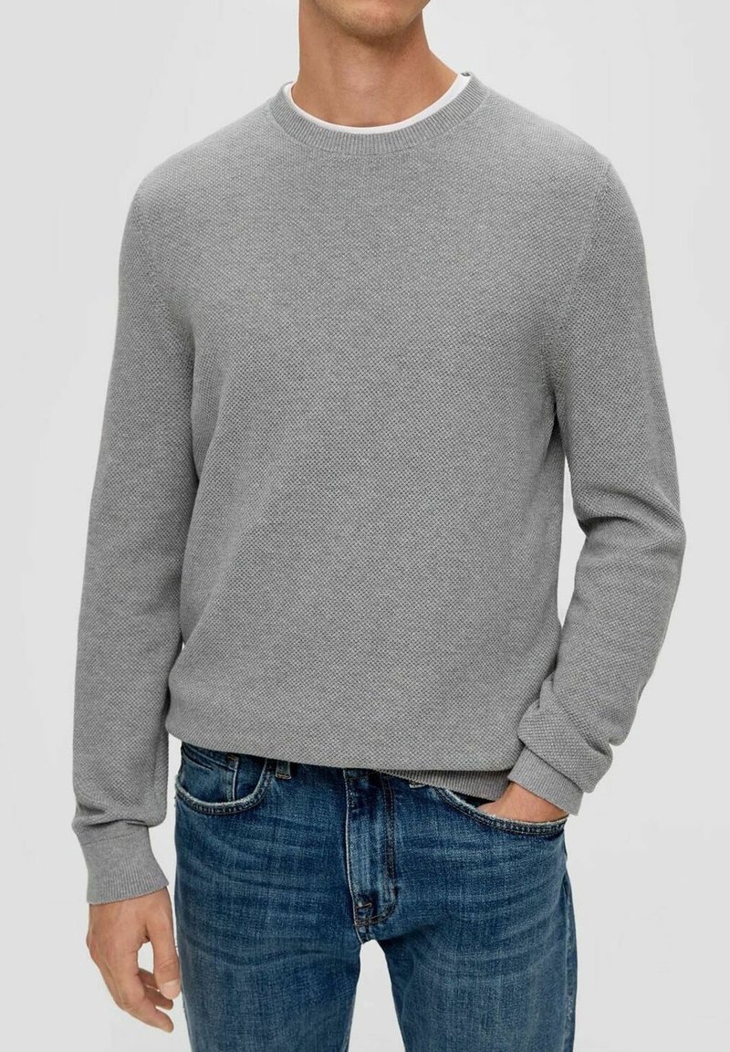 Graues Sweatshirt mit Struktur, Rundhalsausschnitt und gerippten Bündchen, kombiniert mit blauen Denim-Jeans. Legere Passform mit schlichtem Design.
