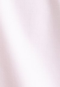 Tissu rose clair texturé avec un motif en nid d'abeille, présentant des ombres douces et des plis subtils.