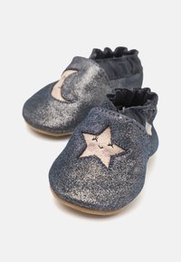 Glitrende marineblå stoff-sko med elastisk topp, med beige broderi av måne og stjerner; myk såle; bølget kant for en sikker passform.