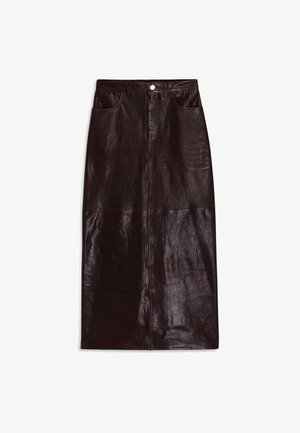 Jupon en cuir marron, longueur genou, avec une texture lisse, poches avant et une fermeture à bouton unique à la taille.