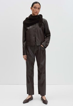 Brown faux leather jacket with a cropped design and two front pockets, paired with matching trousers and a dark knitted scarf.