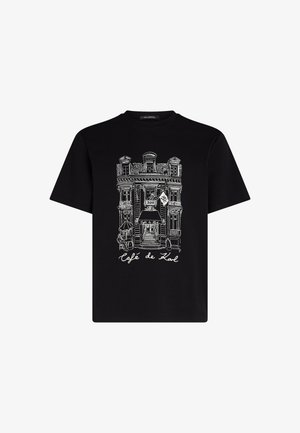 T-shirt noir avec un dessin en ligne blanche d'une façade de café portant le texte "Café de Karl" et des détails architecturaux, manches courtes, coupe classique.