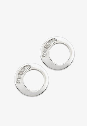 Srebrne kolczyki w kształcie koła z gładkim wykończeniem i akcentem przezroczystego kamienia szlachetnego po jednej stronie, z pustym środkiem i polerowaną fakturą.