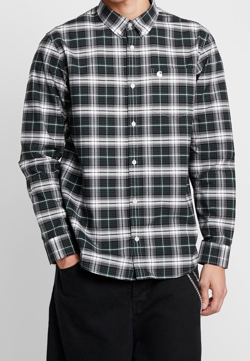 Vihreä-valkoraidallinen nappipaita, jossa on pitkät hihat, kaulus ja rintatasku; valmistettu sileästä kankaasta, jossa on jämäkkä istuvuus.