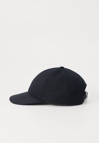 Sort bomulds baseball cap med en buet skygge, seks ventilationshuller og en justerbar rem bagpå. Glat tekstur, enkelt design.