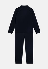 Navy blue thermal set including a long-sleeve top and pants, featuring a ribbed texture and contrasting seams, designed for warmth.