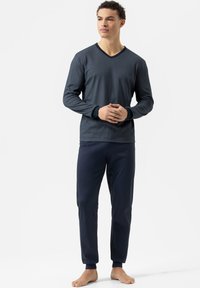 Marynarski, w paski, długi rękaw, bluzka z dekoltem w serek i prążkowanymi mankietami, w połączeniu z gładkimi, ciemnoniebieskimi spodniami z elastycznymi mankietami, wykonanymi z miękkiego materiału.