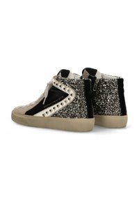 Zapatillas altas con una combinación de colores negro y beige, que cuentan con acentos brillantes, ante texturizado, tachuelas de metal y un cierre de cremallera en la parte posterior.