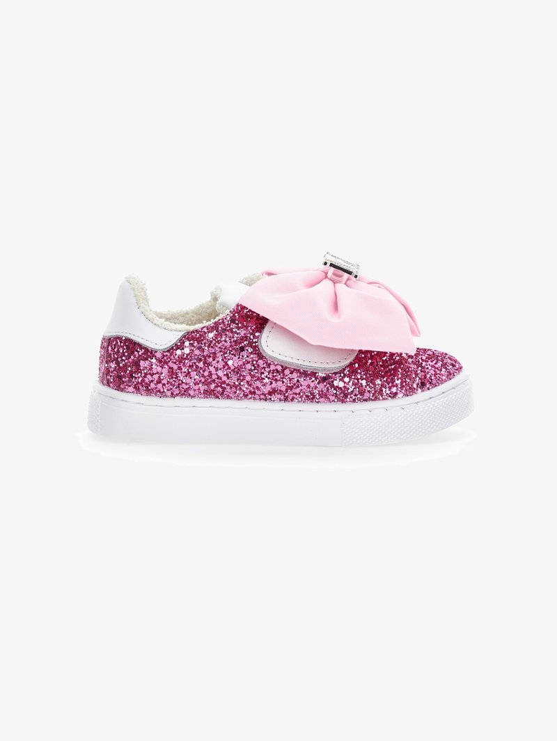Zapatilla infantil brillante de color rosa con suela blanca, que presenta un gran lazo rosa en la parte frontal y un interior suave y texturizado.